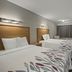 Red Roof Inn Greensboro Airport guest room with two double beds, TV, dresser, and window in Greensboro
