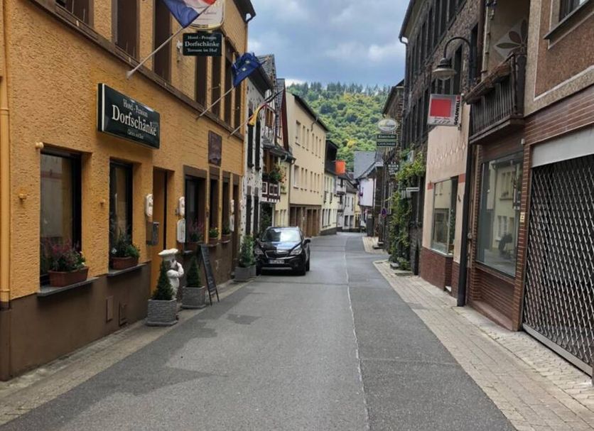 Hotel Pension Dorfschänke in Klotten on a quiet village street with hillside backdrop