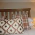 The Kings Head in Meifod guest room with plaid pillows, patterned cushion, and bedside lamp