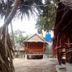 Relax Beach House in Ko Lanta features rustic thatched bungalows with a sandy outdoor walkway.