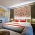 The Lalit London, London: elegant hotel room with tufted sofa, king bed and decorative wall art