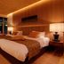 Sakahijiri gyokushoen in Izu: warm guest room with twin beds, wood-paneled walls and balcony seating