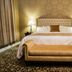 The Mount Vernon Grand Hotel room with king bed, upholstered bench, and bedside lamps in Mount Vernon