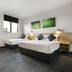 Nightcap at St Albans Hotel room with two beds, desk, window and wall art in Saint Albans