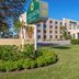 La Quinta Inn & Suites by Wyndham Sarasota Downtown exterior with landscaped lawn and entrance