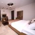 Zifan Hotel & Suites in Karachi guest room with bed, sofa, TV, and ceiling fan