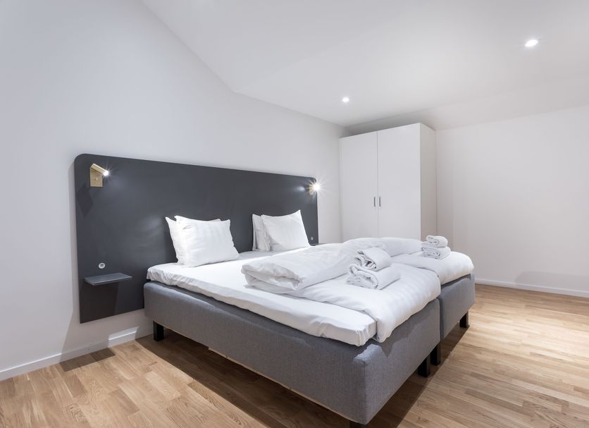 Apartdirect Sundbyberg bedroom with double bed, white linens, bedside lamps and wardrobe