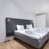 Apartdirect Sundbyberg bedroom with double bed, white linens, bedside lamps and wardrobe