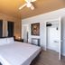 Notebook Miami Beach guest room with king bed, ceiling fan, open closet and patterned accent wall