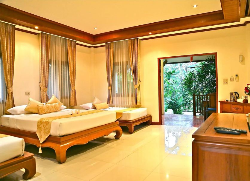 Oriental Siam Resort Chiang Mai bedroom with twin beds and garden view through open doorway