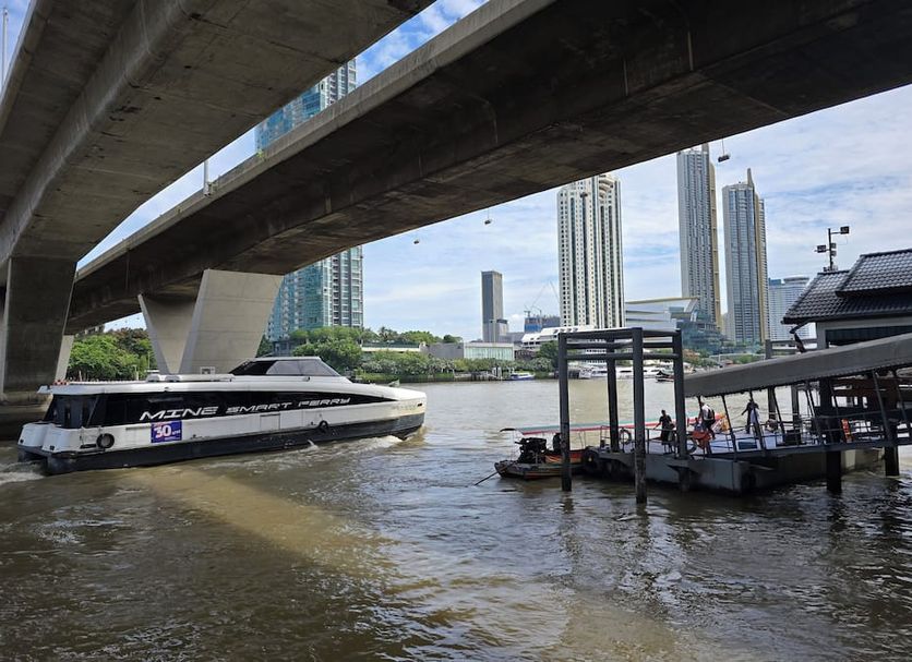 Somewhere to Escape - Hometel in Bangkok with a boat dock by the river under an elevated bridge