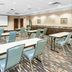 Hampton Inn Pittsburgh-Bridgeville meeting room in Bridgeville with tables, chairs, and presentation screen