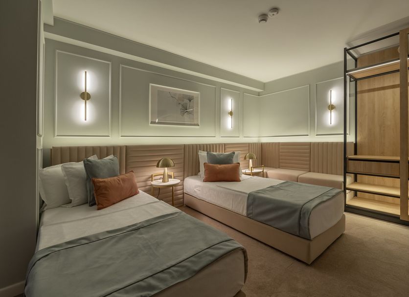 Hotel Bavaria Blu in Mamaia guest room with twin beds, wall lights and a wooden bunk bed frame