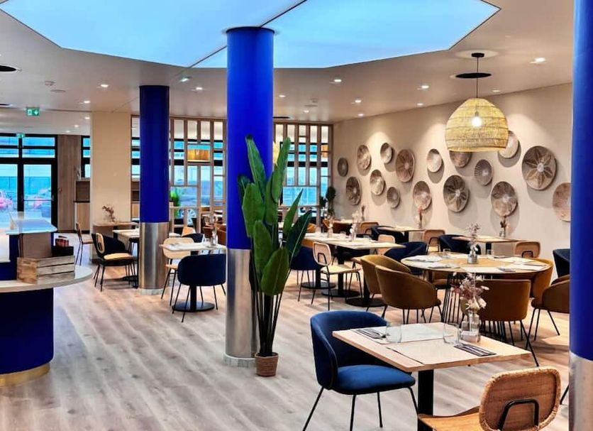 7Hotel&Spa in Illkirch-Graffenstaden restaurant with blue columns, tables, and wall decor