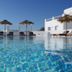Margie Mykonos Hotel in Mykonos: rooftop pool with loungers, thatched umbrellas and sea view
