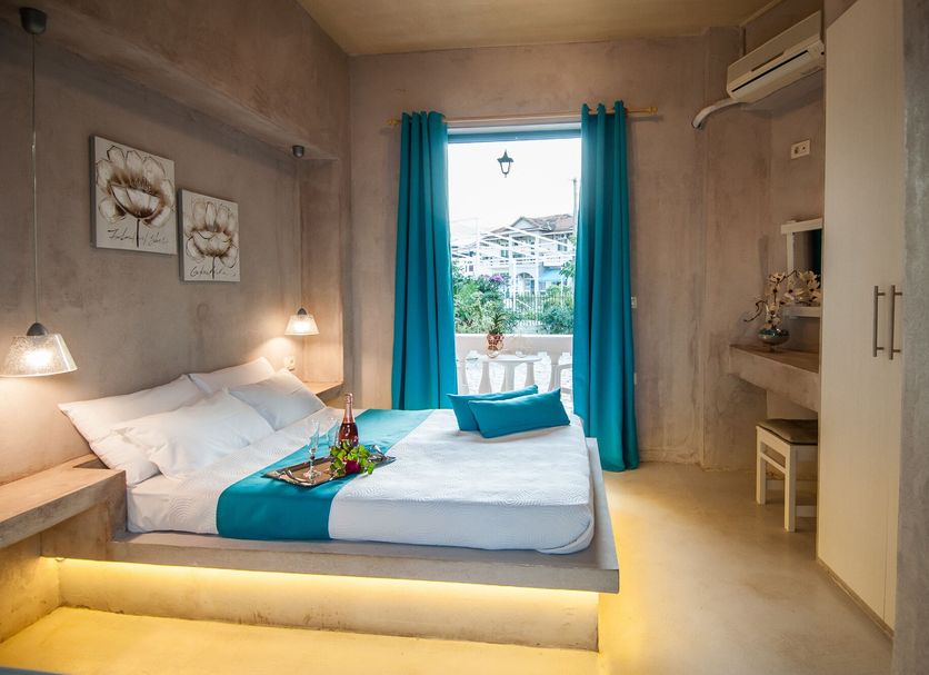 Zante Nest Studios & Apartments in Zakynthos, bedroom with turquoise curtains and balcony view