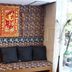 Ideal Hotel Pratunam in Bangkok lobby seating nook with patterned bench, cushions, and red wall hanging
