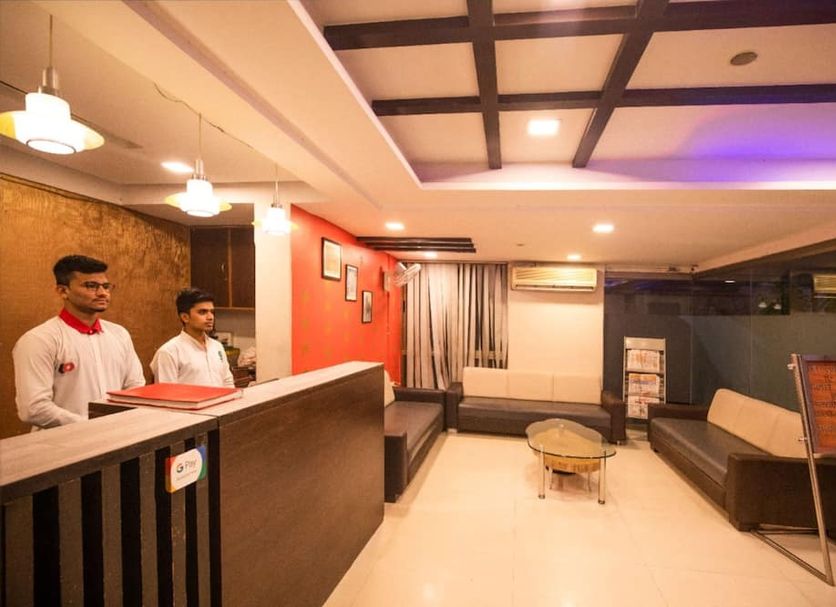 Hotel Shrimad Residency Ahmedabad lobby with reception desk, seating area, and modern ceiling lights
