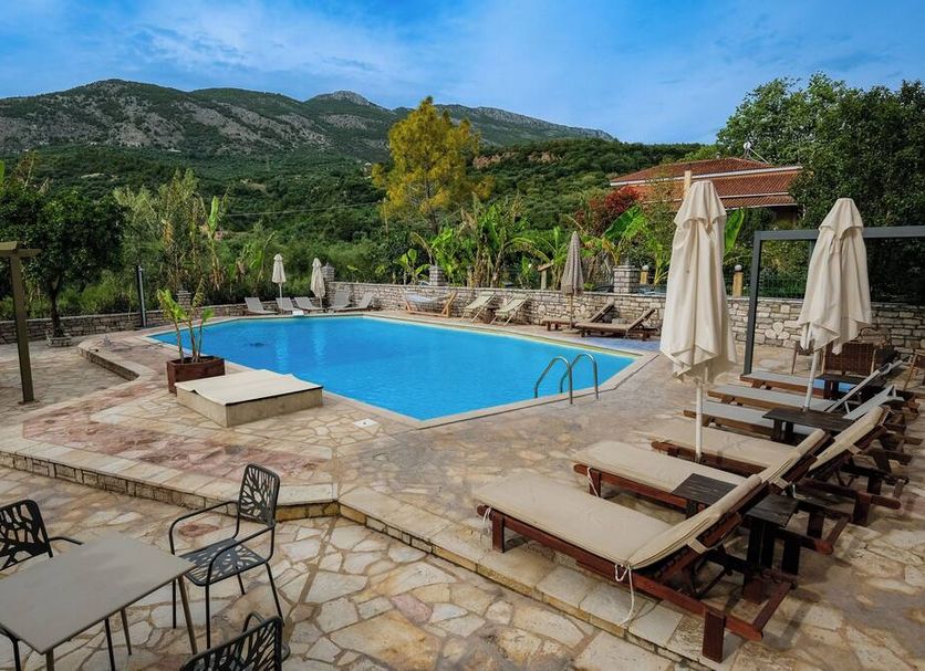 Kaiafas Lake Hotel in Zacháro: outdoor pool with loungers, umbrellas and mountain views