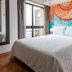 Hotel A.S. Sao Joao da Madeira guest room with bed, balcony door, and colorful mural wall in São João da Madeira