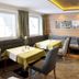 Hotel Sonnschupfer in Schladming dining room with set tables, cushioned benches, and large windows