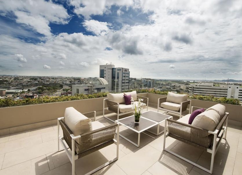 Hilton Colon Guayaquil rooftop terrace with seating and city views in Guayaquil