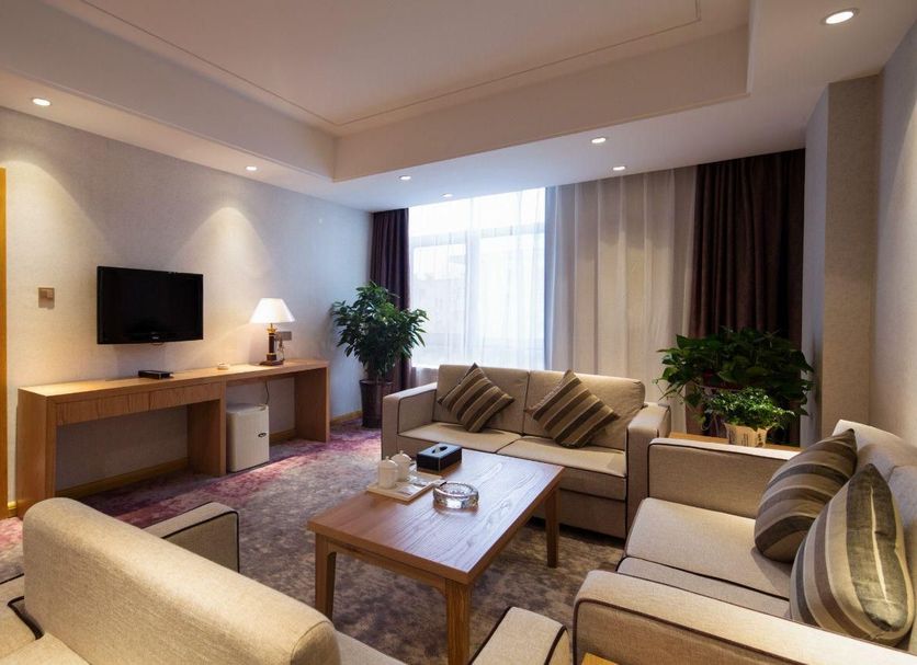 Yong Cun Hotel (Xi'an Bell Tower) in Xi'an, spacious suite with seating area, desk, and city view