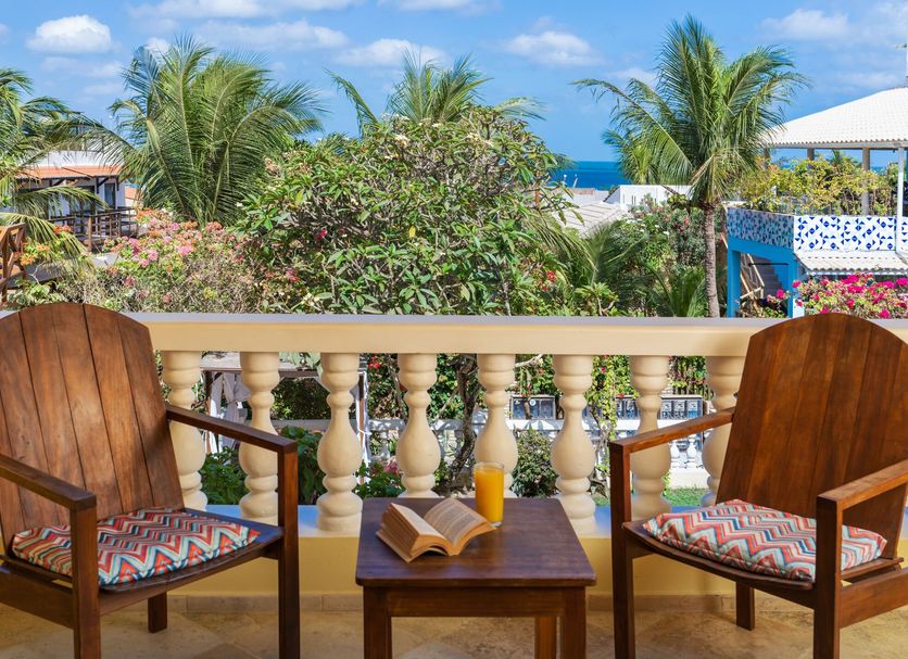 Hotel Villa Terra Viva balcony with chairs, table, and ocean view in Jijoca de Jericoacoara