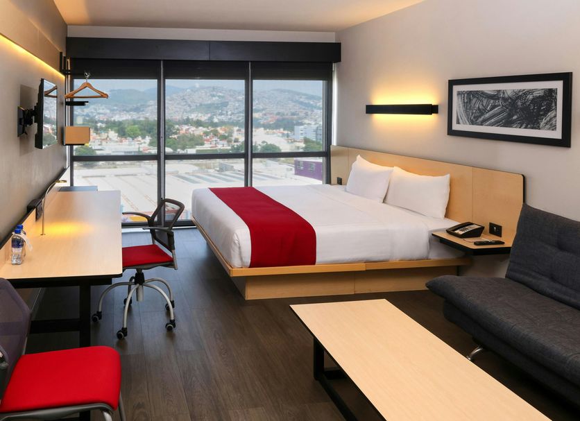 City Express Plus by Marriott Ciudad de México Mundo E guest room with bed, sofa, desk and city view