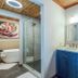 Little Creek Cove Beach Resort Newport bathroom with blue vanity, glass shower and soaking tub