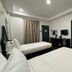 La Planta Hotel And Restaurant in Bais City guest room with two single beds, desk, TV and wardrobe