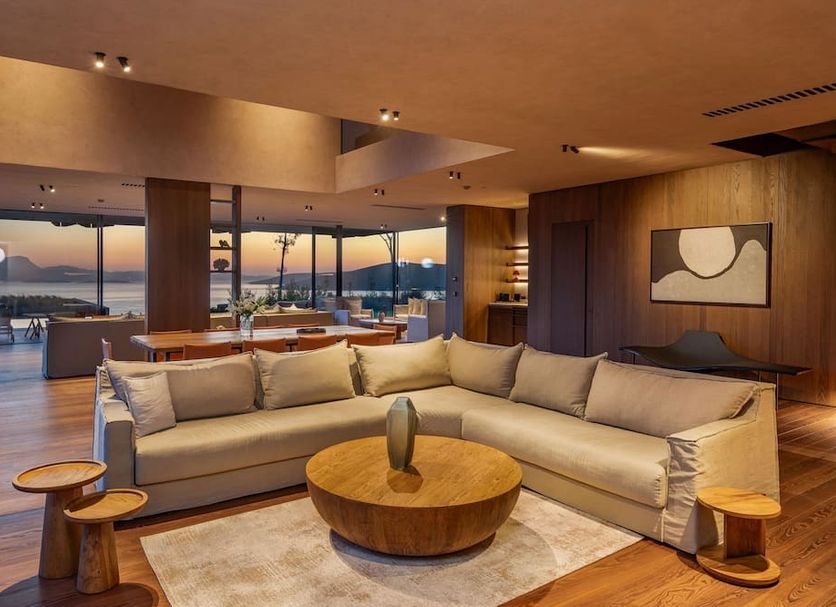 Lujo Hotel Bodrum in Güvercinlik lounge with sectional sofa and sunset sea view through floor-to-ceiling windows
