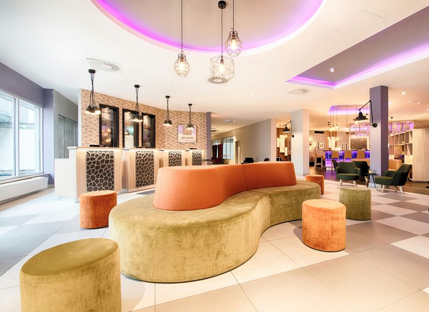 Leonardo Hotel Wolfsburg City Center lobby with curved velvet seating, pendant lights and bar area in Wolfsburg
