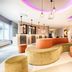Leonardo Hotel Wolfsburg City Center lobby with curved velvet seating, pendant lights and bar area in Wolfsburg
