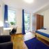 Basement Rotherbaum Hamburg room with twin beds, desk, blue curtains and balcony door