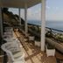 Vivenda Belo Horizonte in Caniço: ocean-view terrace with wicker chairs, white columns and flower boxes