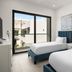 Seascape Hotel in Providenciales guest room with two beds and a balcony view of courtyard buildings