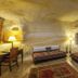 Yunak Evleri Cappadocia cave-style room in Ürgüp with twin beds, stone walls and warm lamps