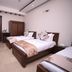 Zifan Hotel & Suites in Karachi guest room with three twin beds and wall-mounted TV