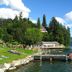 Pension zum Mühlrad in Millstatt with lakeside dock, swimmers, and sunbathers by the water