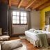 Hotel & Spa Etxegana room in Zeanuri with carved headboard, king bed, wooden ceiling and window view