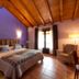 Hotel-Apartamento Rural Atxurra in Bermeo bedroom with wood ceiling, tiled floor, double bed and armchair