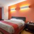 Motel 6 El Paso - Southeast guest room with queen bed, orange accent wall, and window seat