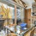 Antlers at Vail suite with fireplace, glass dining table and balcony overlooking autumn trees