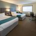 Paynesville Inn And Suites guest room with two queen beds, desk, chair, and window in Paynesville