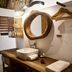 El Alquimista Yoga Spa in Zipolite bathroom with wooden vanity, vessel sink and round mirror