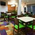 Fairfield Inn & Suites by Marriott Odessa breakfast area with tables, green chairs and colorful carpet