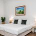 Cove Studios in Byron Bay guest room with king bed, bedside lamps, and framed beach artwork