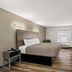 Quality Inn & Suites Biloxi - Ocean Springs guest room with king bed, desk, and wall-mounted TV