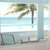 Bravo Beach Hotel in Vieques with ocean view, palm tree, and patio chairs by a pool